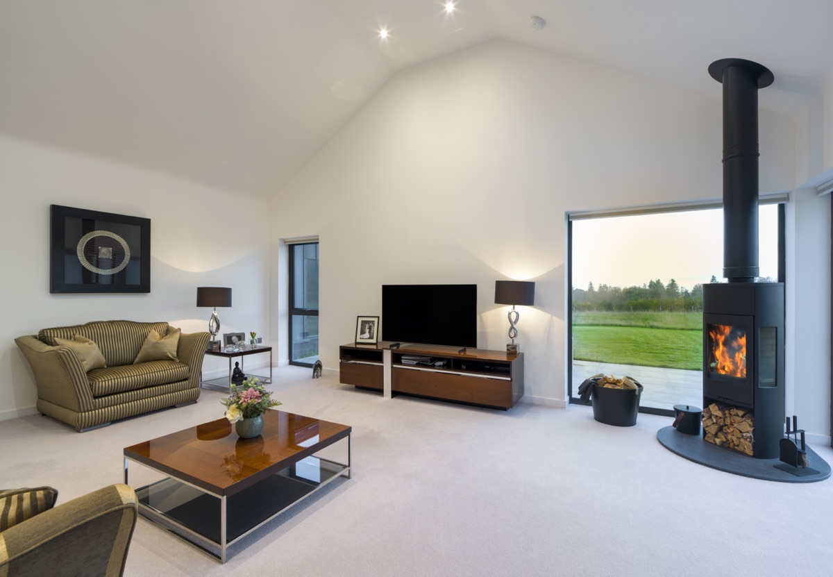 Traditional granite cottage with a contemporary timber-clad extension against heather-covered hills